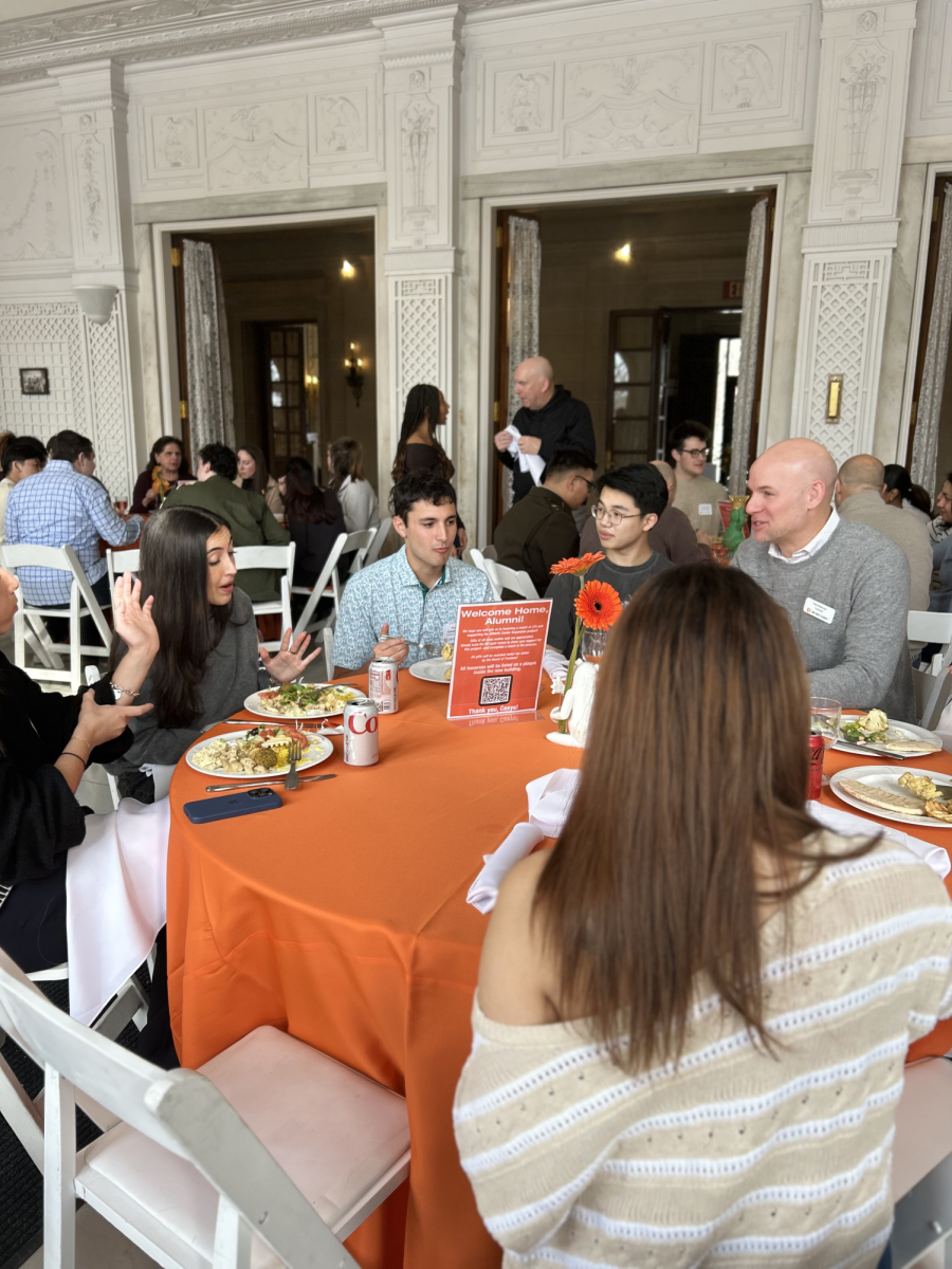 Conversations fill the garden room as young alumni return to campus.