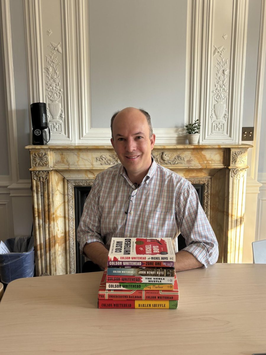 Bird Master Teaching Chair Jonathan Freeman sits with a set of Colson Whitehead novels.