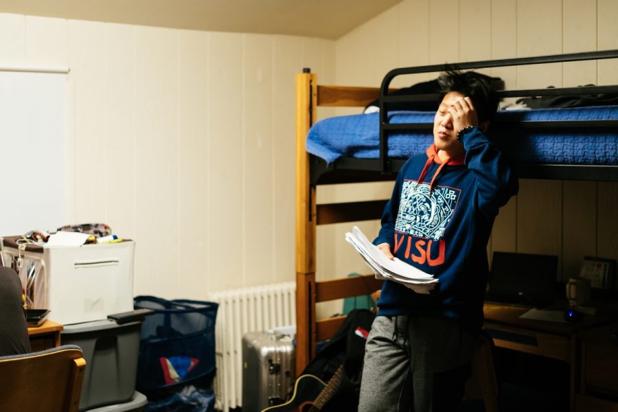  Freshman Tony Lu shows signs of fatigue in his room while studying for a test and balancing dorm life. 
