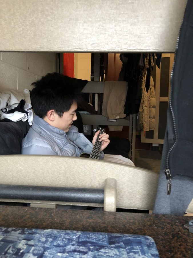 Clint Shi kills time in his Atlass dorm room by playing his ukulele.
