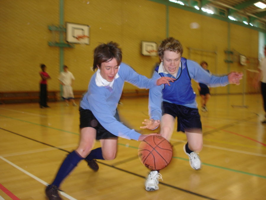 Two boys playing an intense round of basketball during PE.