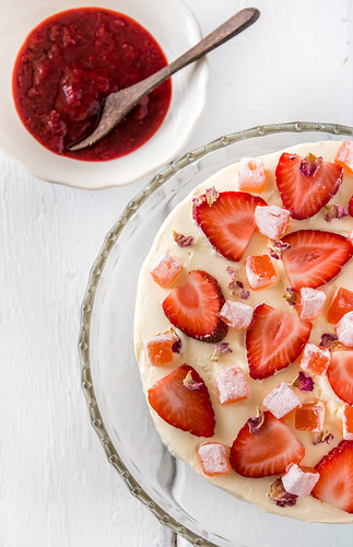 A tres leches cake on display, topped with strawbeerries.