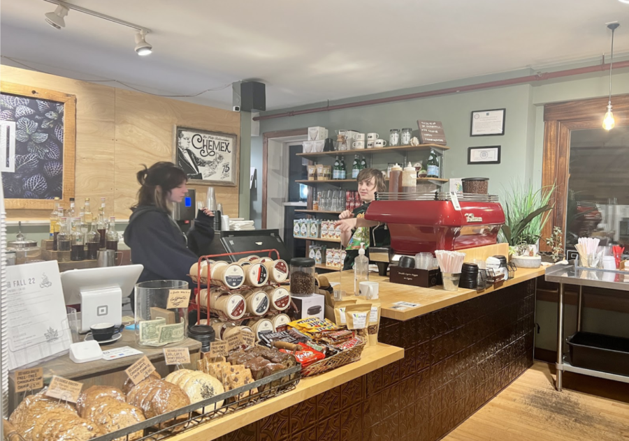 Two employees are chatting as they make coffee at Hansas Café. 