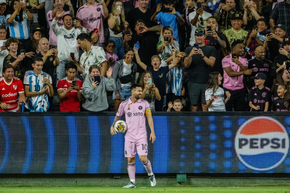 Lionel Messi smiling toward the crowd.