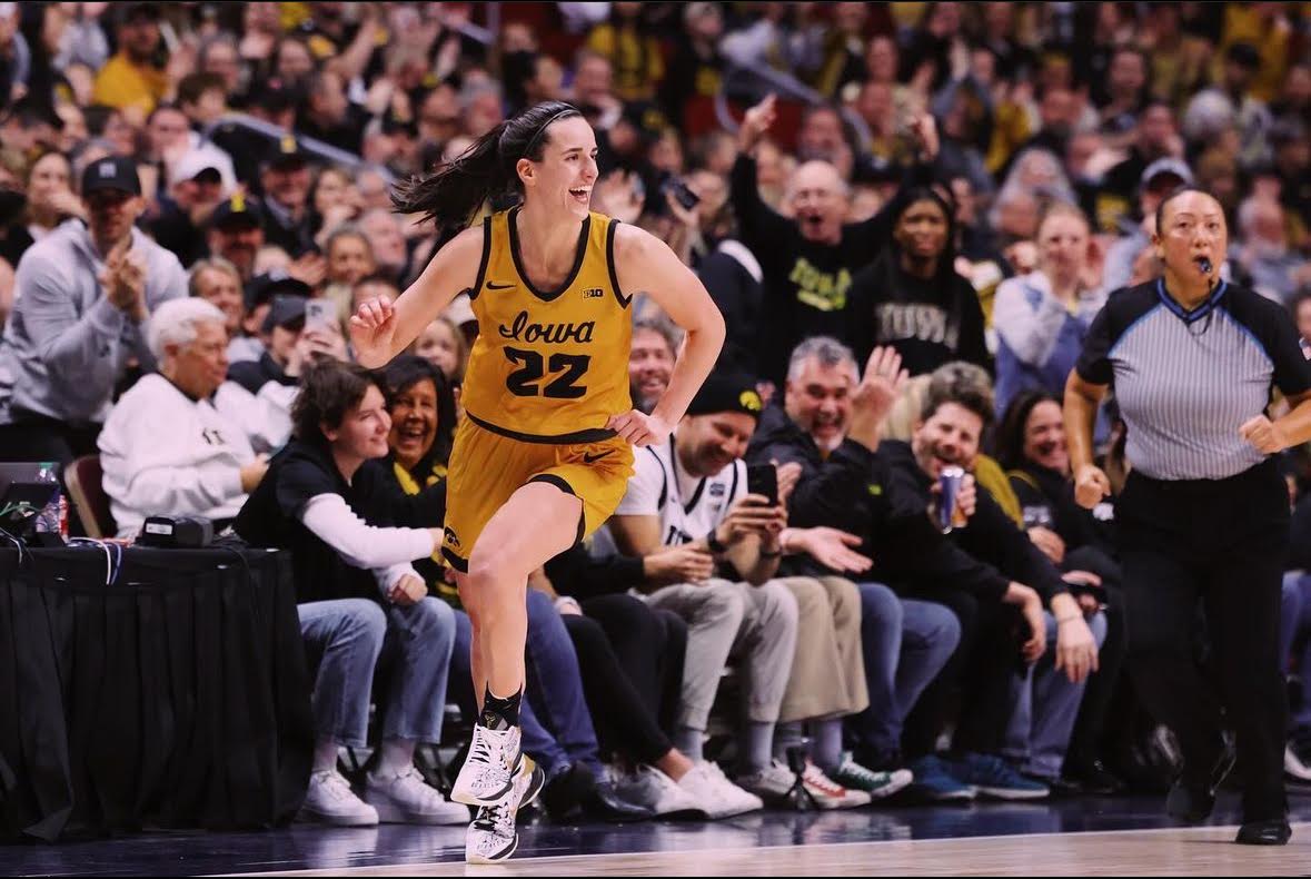 Catkin Clark and the Iowa Hawkeyes lift the regional trophy after winning the Elite Eight.