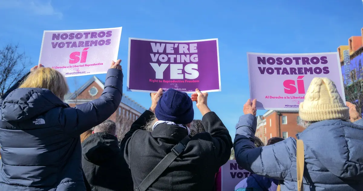 Women march with signs in favor of an abortion referendum during a Maryland protest.