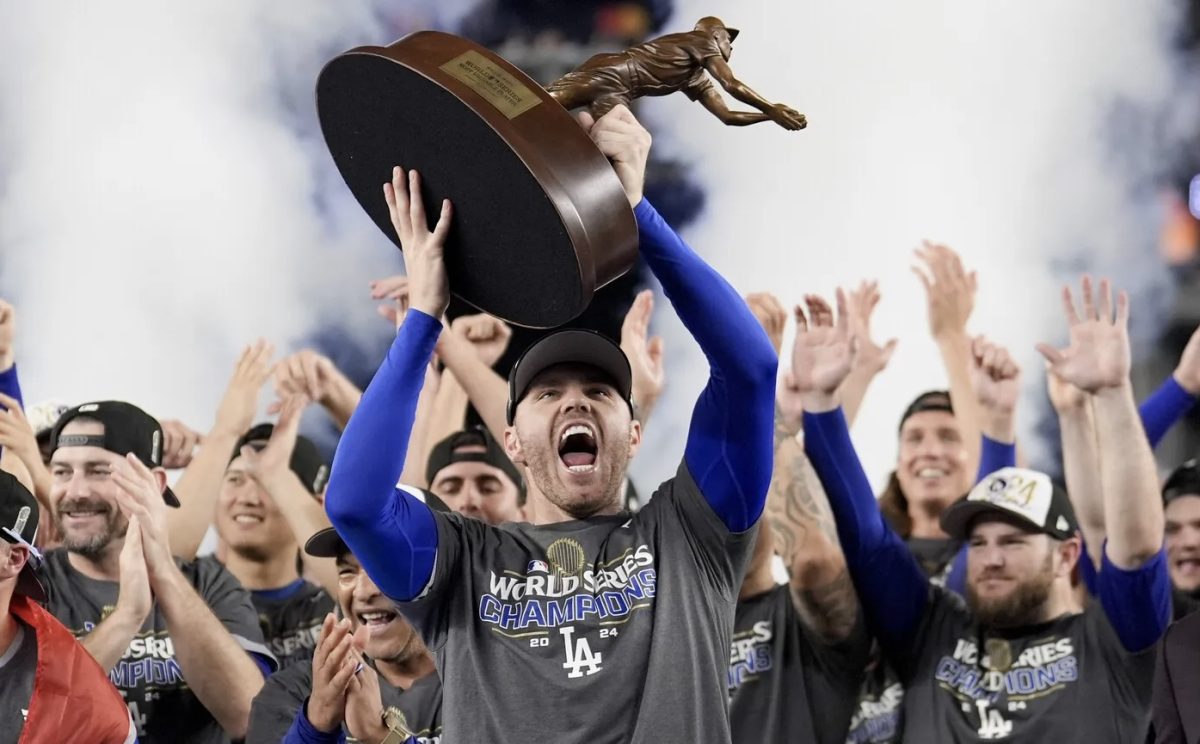 Freddie Freeman raises the World Series MVP trophy over his head after leading the Los Angeles Dodgers to victory over the New York Yankees.