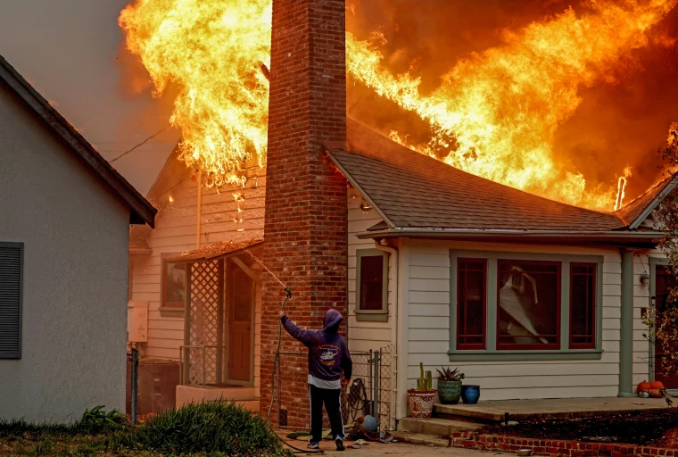 Picture of a house being consumed by the wildfire flames. (Courtesy of NBC News)