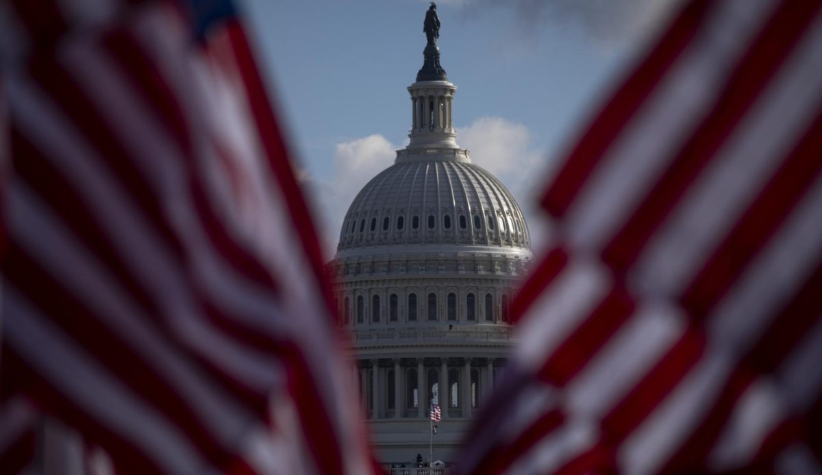 The U.S. Capitol divides two American flags near the Air & Space Museum in Washington, D.C.