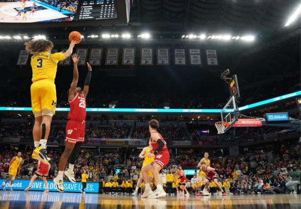Michigan’s Tre Donaldson shoots a contested three against Wisconsin in the Big 10 tournament 
