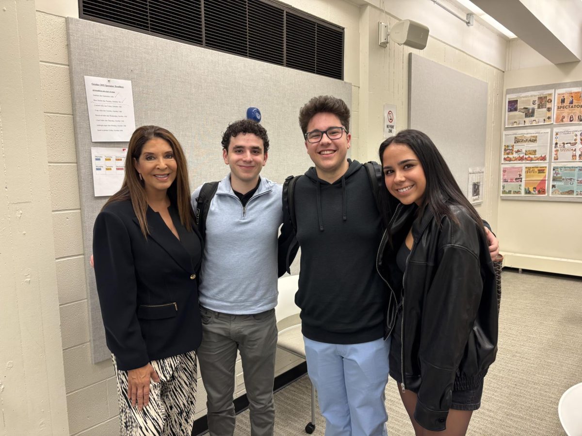 Christine Devine poses in a classroom with journalism students.