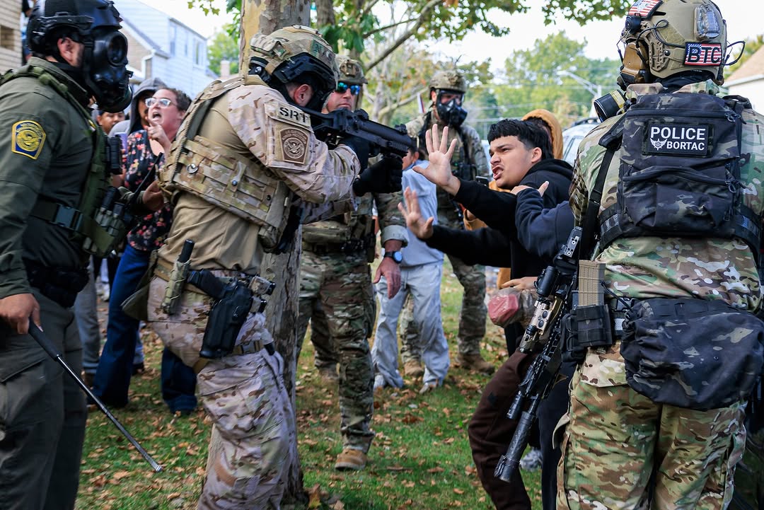 A law enforcement officer points a gun at a protester in Chicago on October 14.
