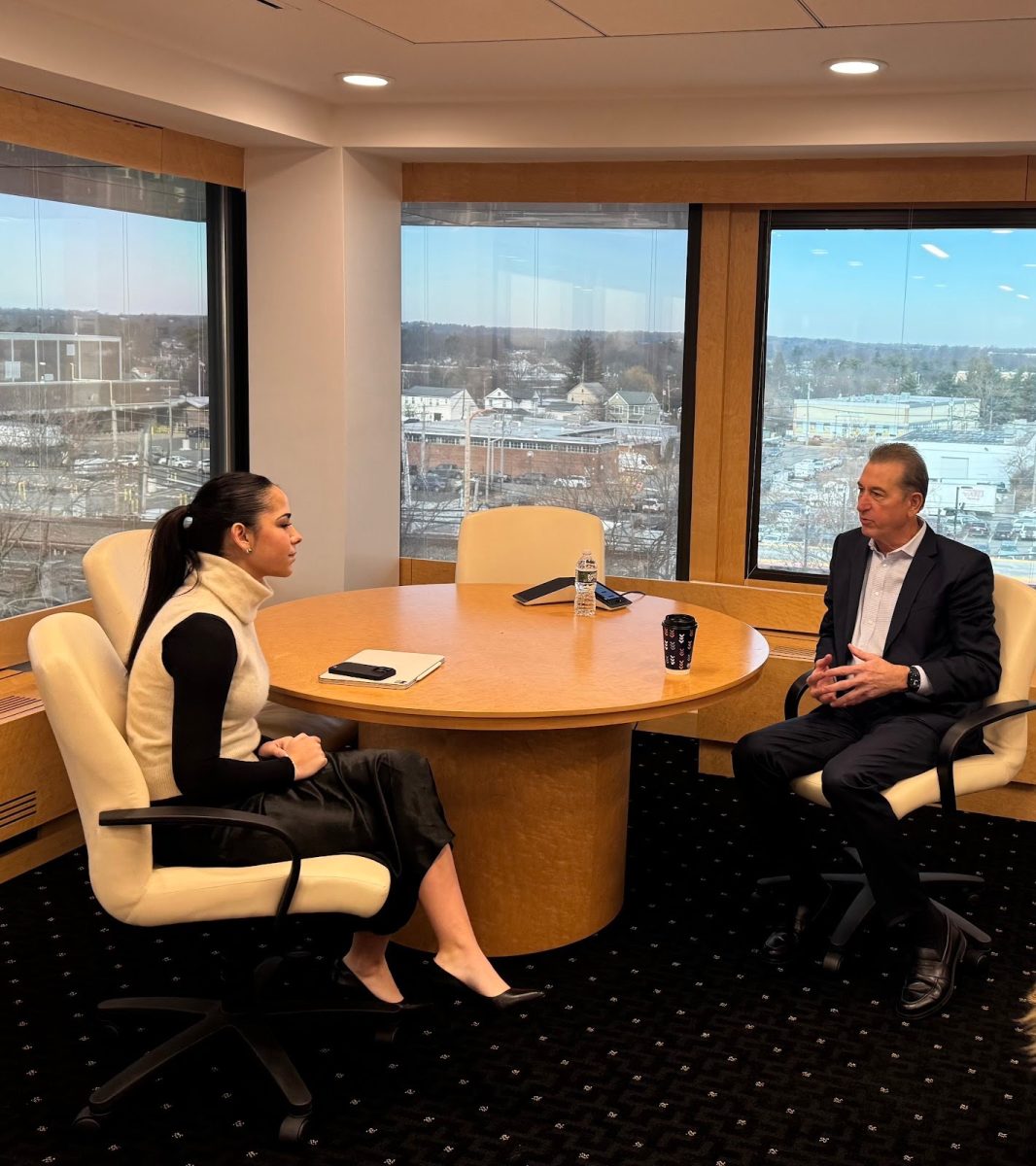 Mary Scheeringa ‘26 sits inside the Flagstar headquarters in Hicksville, New York with Joseph Otting.