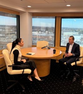 Mary Scheeringa ‘26 sits inside the Flagstar headquarters in Hicksville, New York with Joseph Otting.