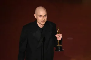 Daniel Blumberg accepts his Oscar award for “Best Original Score” in 2025.