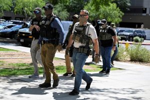 Masked law enforcement officers, including HSI and ICE agents, walk into an immigration court in Phoenix, Arizona, U.S, May 21, 2025.