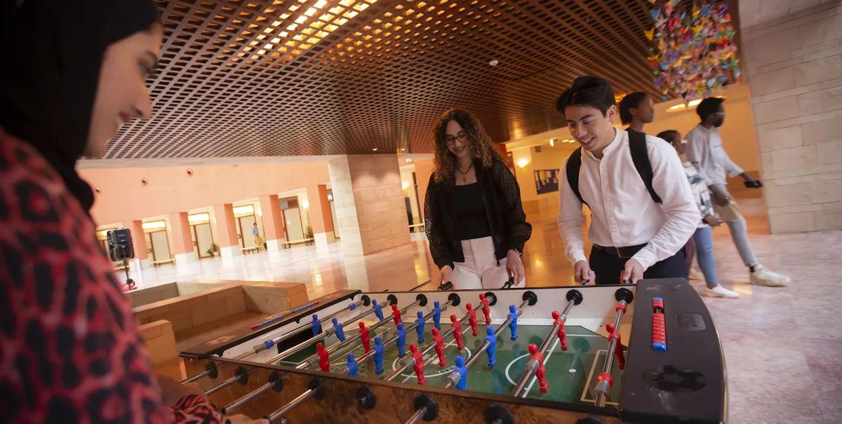 CMU-Q students playing table football in the Assembly area.