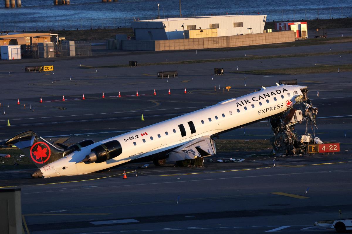 The defunct Air Canada Express plane stands on Runway 4 at LaGuardia airport after its collision.