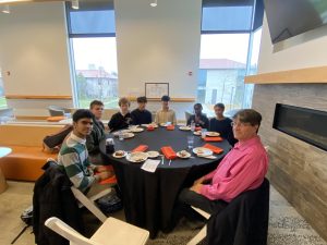 Students sit together at a Lunch and Learn event with Dr. John Freeland '86.